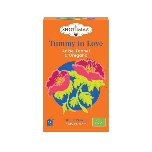 A box of Shot in Maa Tummy in Love herbal tea, featuring a bright orange background with a colorful illustration of pink flowers and green leaves on a blue circle.
